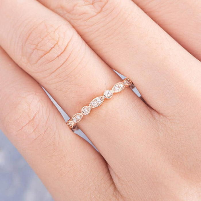 Round moissanite vintage milgrain full eternity wedding band in rose gold worn on a finger