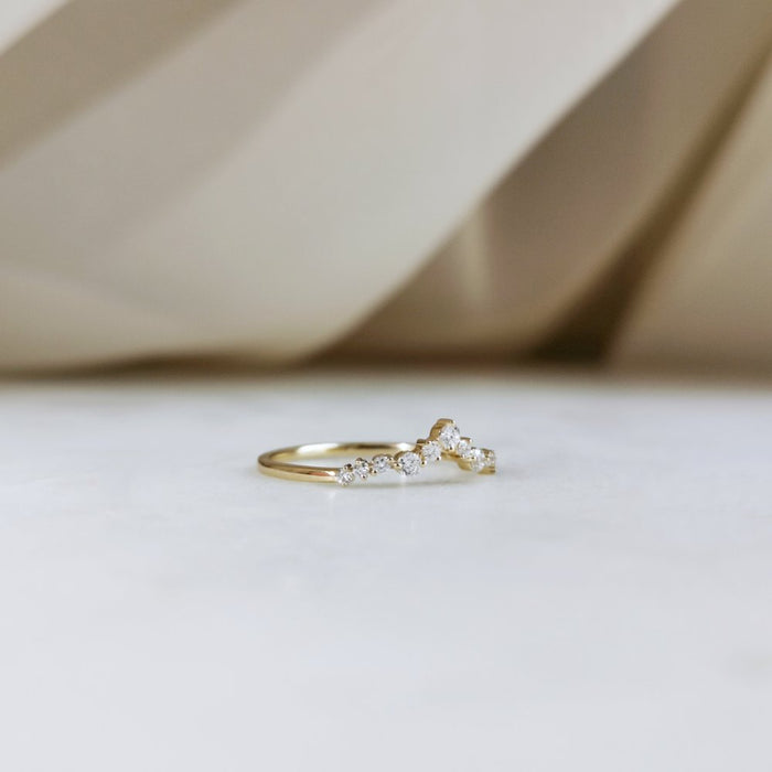 Curved moissanite wedding band in gold side view