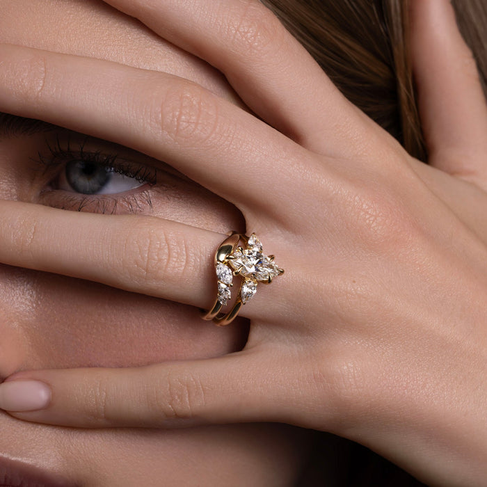 Curved marquise moissanite band worn beside a marquise engagement ring