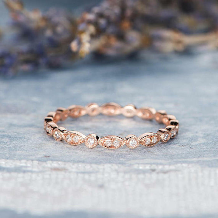 Rose gold vintage milgrain full eternity band with round and navette moissanite settings on blue velvet