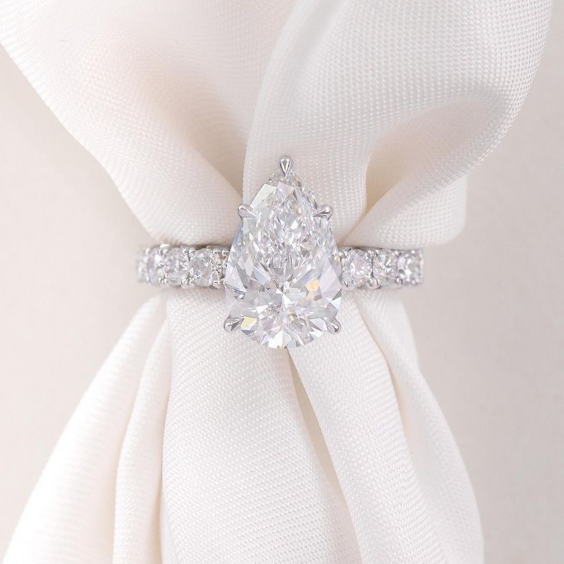 Pear cut moissanite hidden halo engagement ring in gold