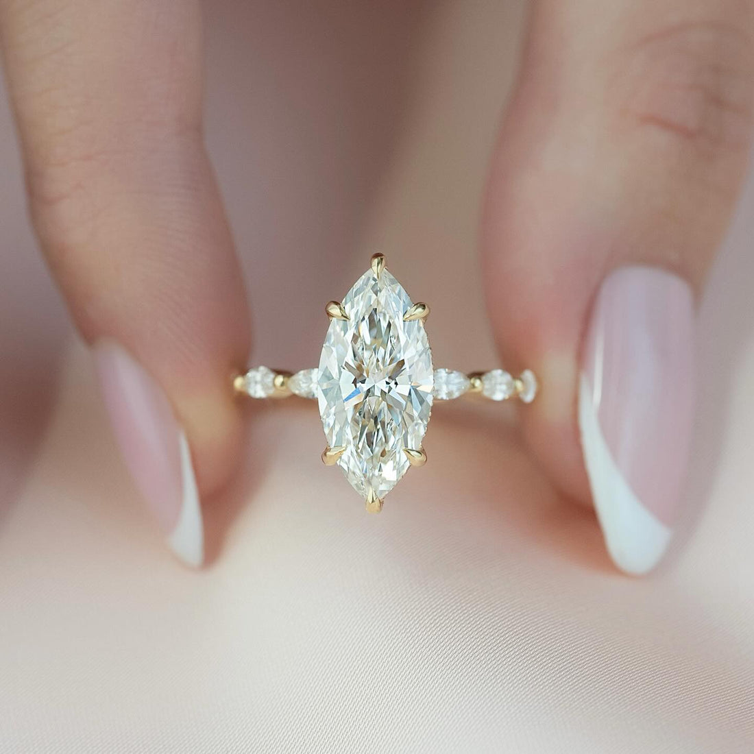 Marquise cut lab grown diamond ring in yellow gold with six claws and graduated marquise accents