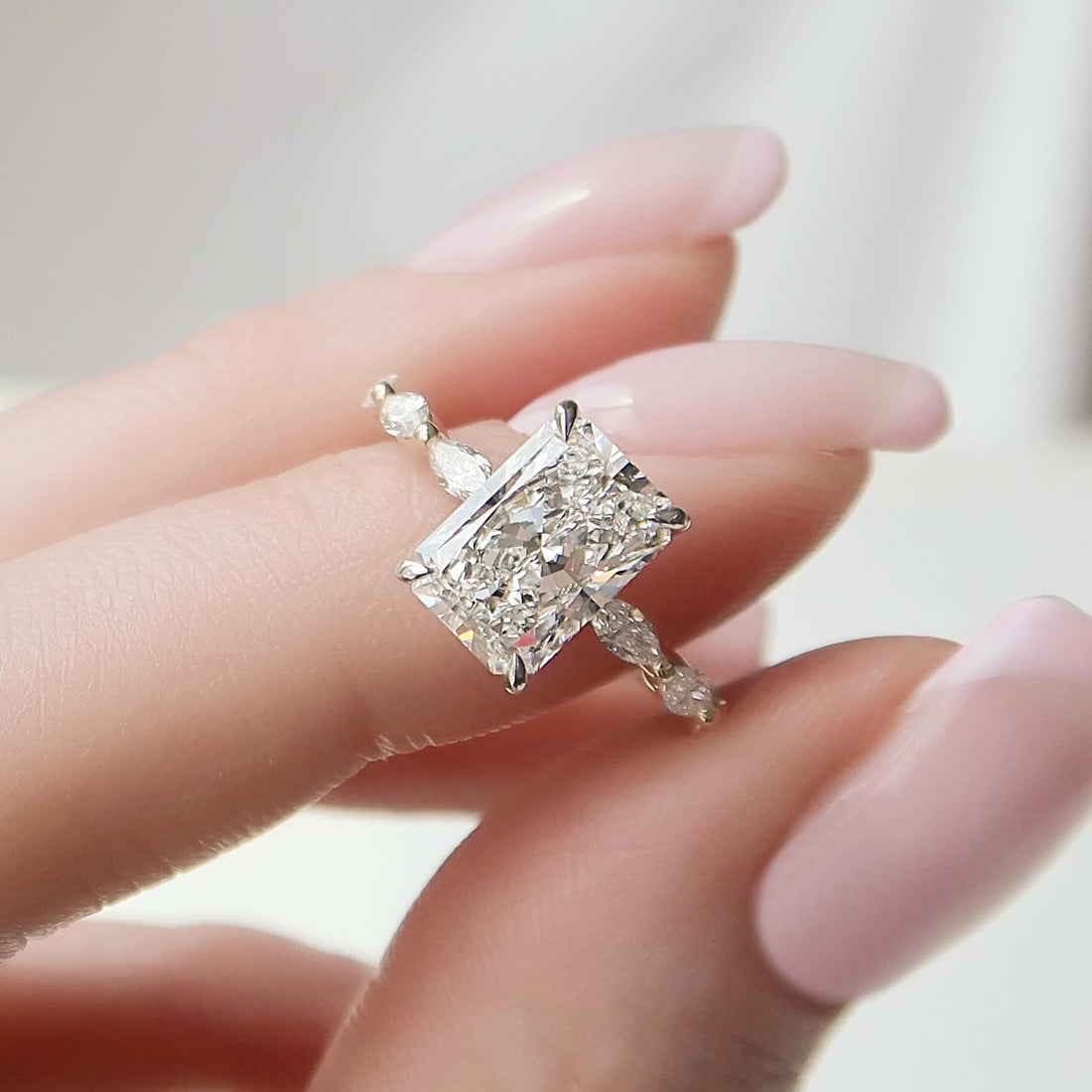 Radiant cut lab grown diamond ring in white gold with graduated marquise accents along the shank