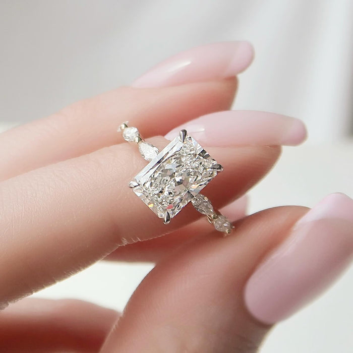 Radiant cut lab grown diamond ring in white gold with graduated marquise accents along the shank