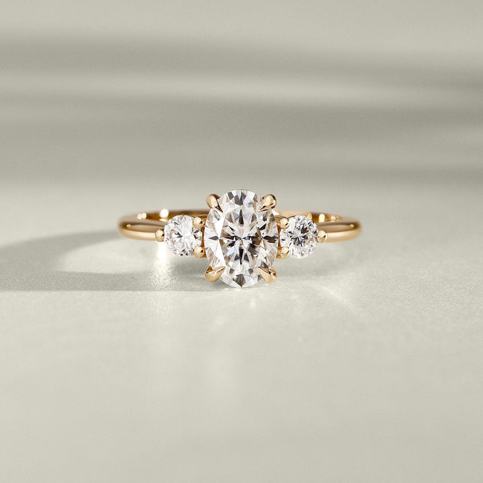 Oval cut lab grown diamond three stone ring in yellow gold