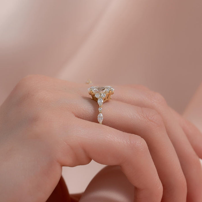 Oval moissanite cluster ring with marquise accent band in yellow gold