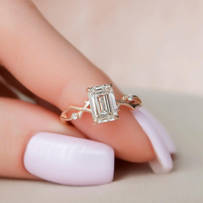 Emerald cut lab grown diamond ring on a twisting vine band with carved leaves and set accents