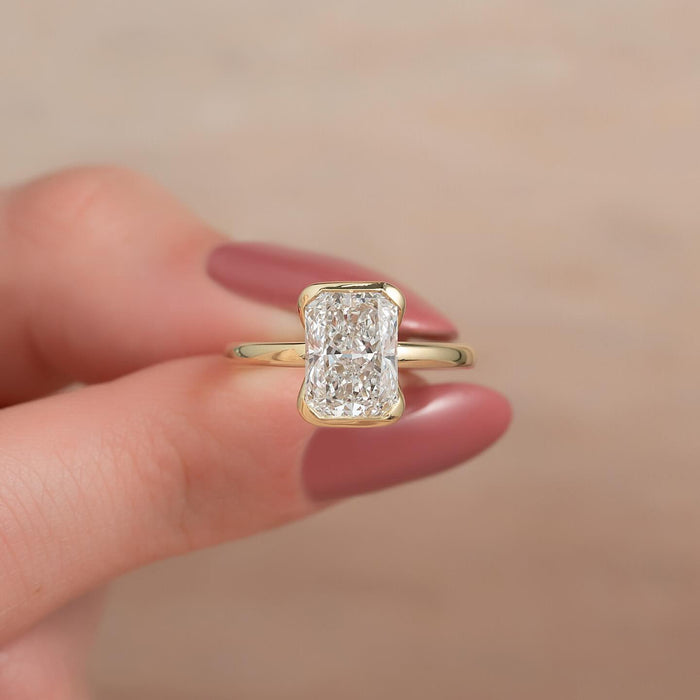 Elongated radiant cut lab grown diamond half bezel ring in yellow gold