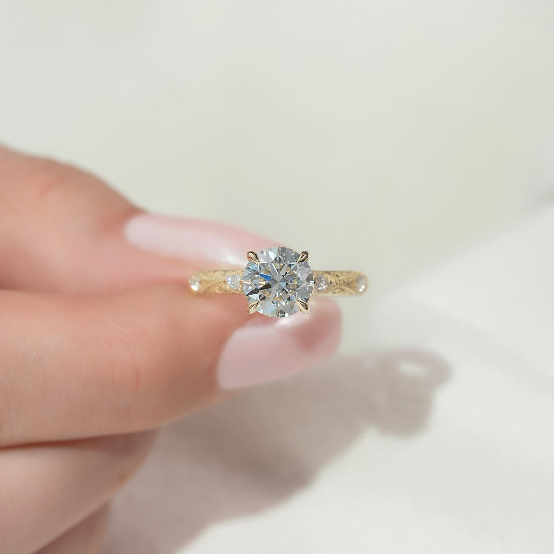 Round moissanite vintage engraved accent ring in yellow gold