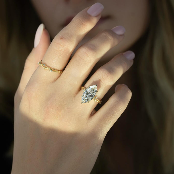 Marquise cut lab grown diamond solitaire ring on a carved branch band in yellow gold worn on the hand