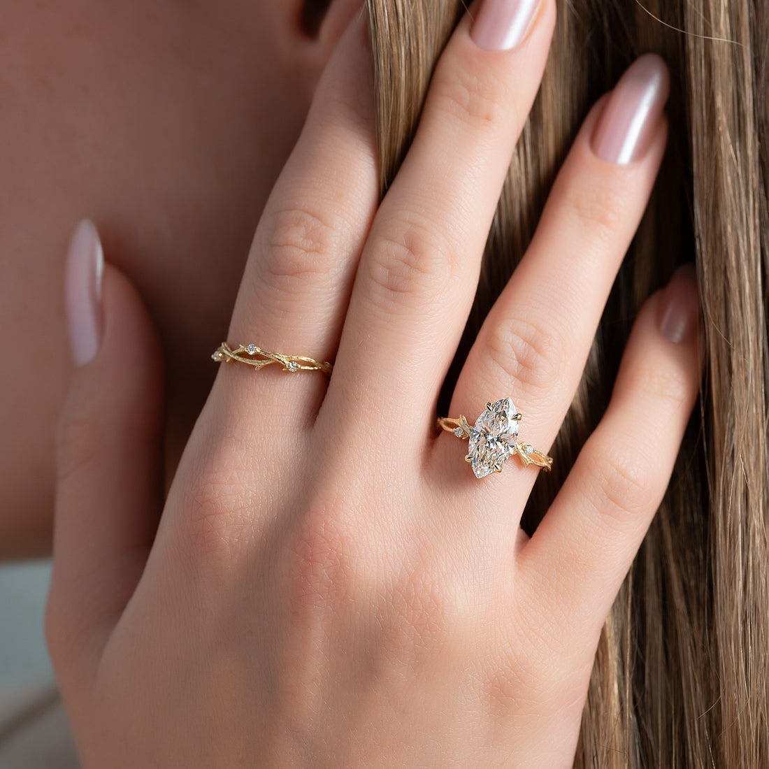 Marquise cut lab grown diamond ring with twig and leaf band in yellow gold worn on the hand
