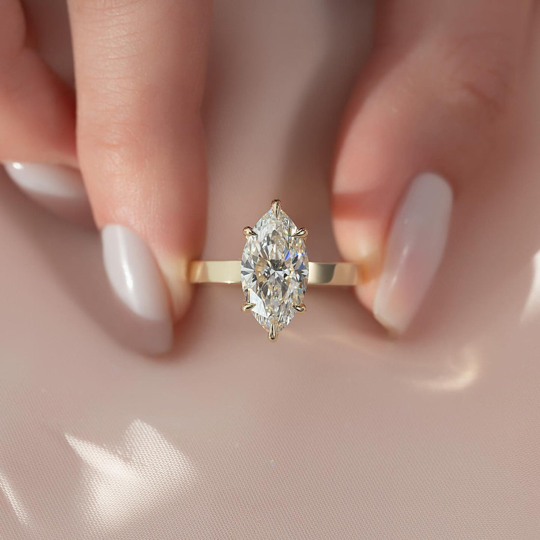 Marquise cut lab grown diamond solitaire on a wide flat yellow gold band