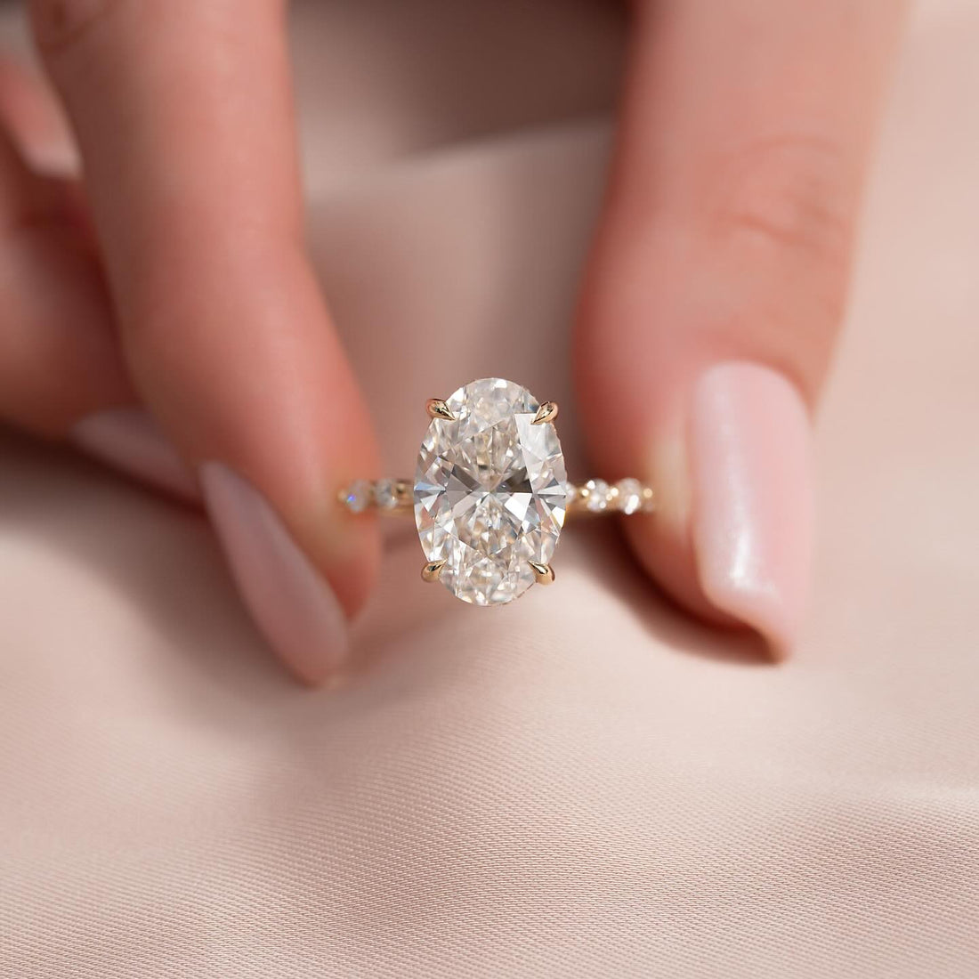 Oval moissanite hidden halo round accent band ring in yellow gold