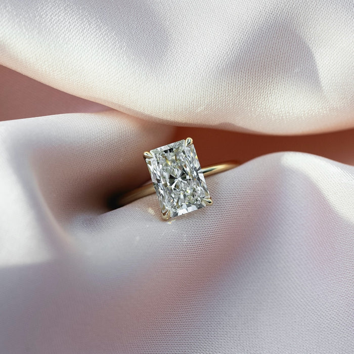 Elongated radiant cut lab grown diamond ring on a fine yellow gold band