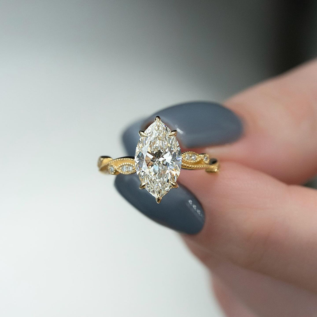 Marquise cut lab grown diamond ring in yellow gold with a milgrain leaf station band