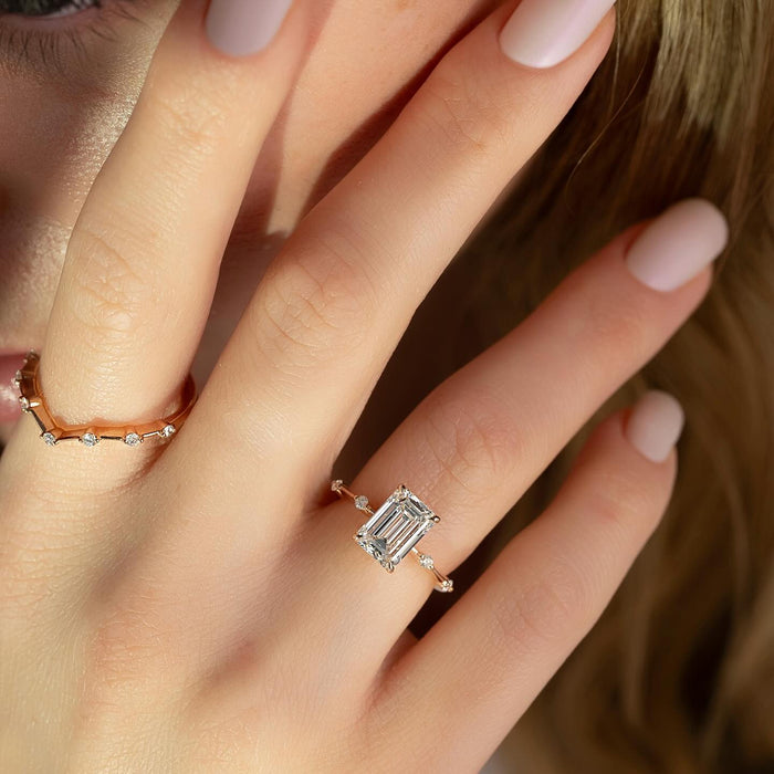 Emerald cut diamond engagement ring worn on the hand