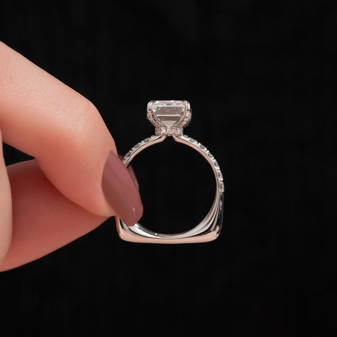 Side view of emerald cut moissanite east west hidden halo pave ring in white gold