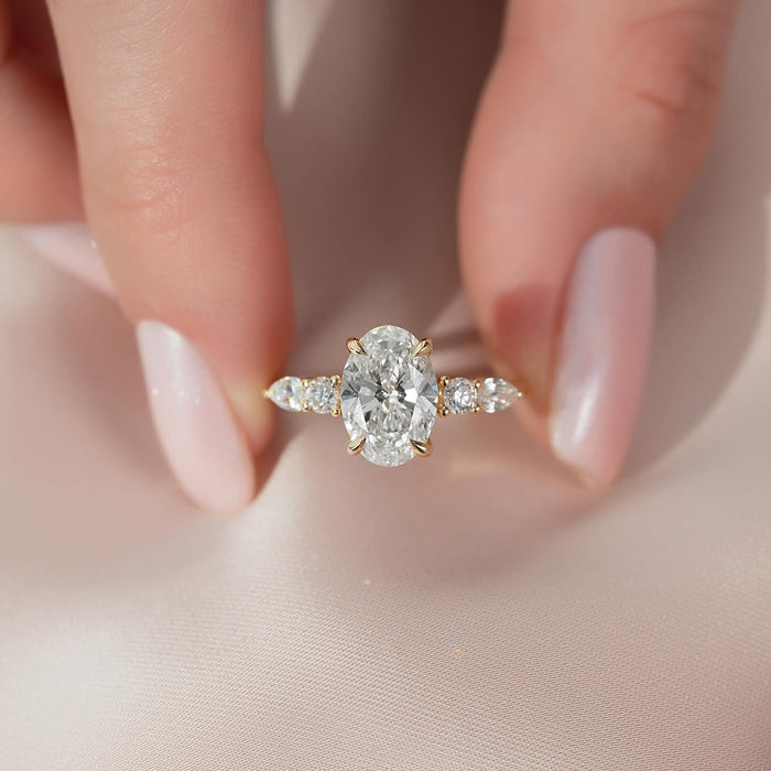 Oval centre diamond with pear shaped side stones and round accents