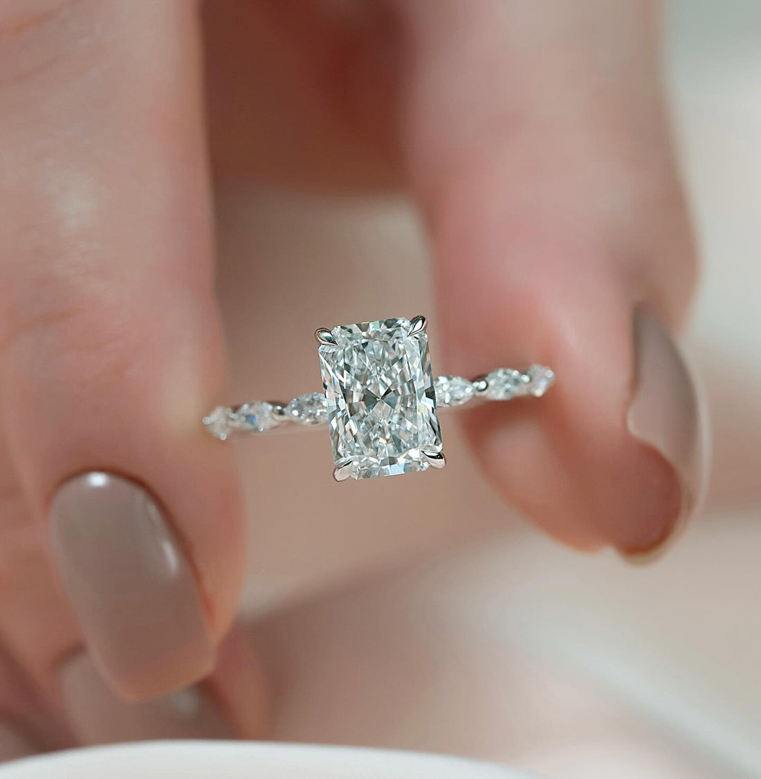 Radiant cut lab grown diamond ring in white gold with crosswise marquise accents on a scalloped band