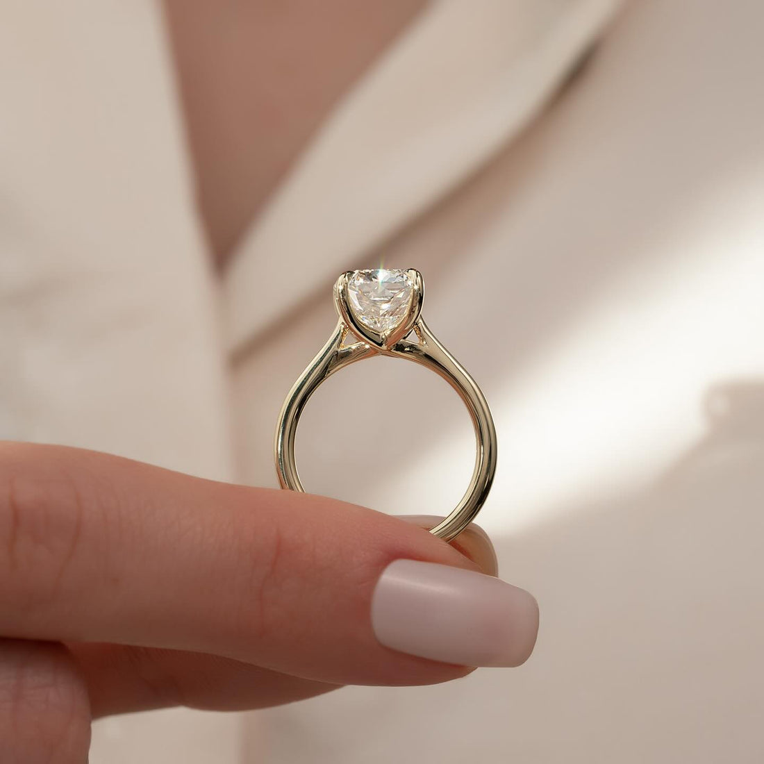 Round moissanite cathedral solitaire ring in yellow gold