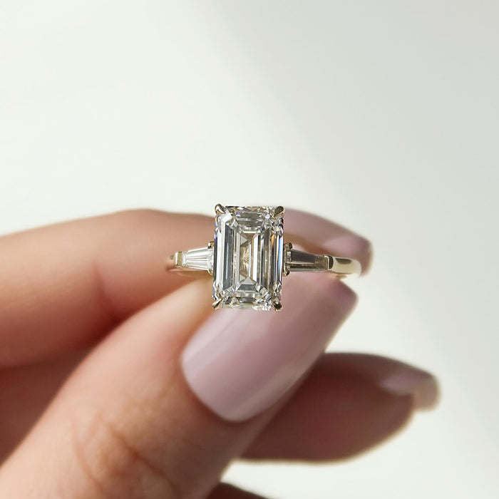 Emerald cut lab grown diamond ring with tapered baguette side stones in yellow gold