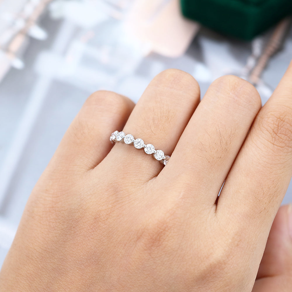 Round moissanite ball prong half eternity wedding band in white gold worn on the finger