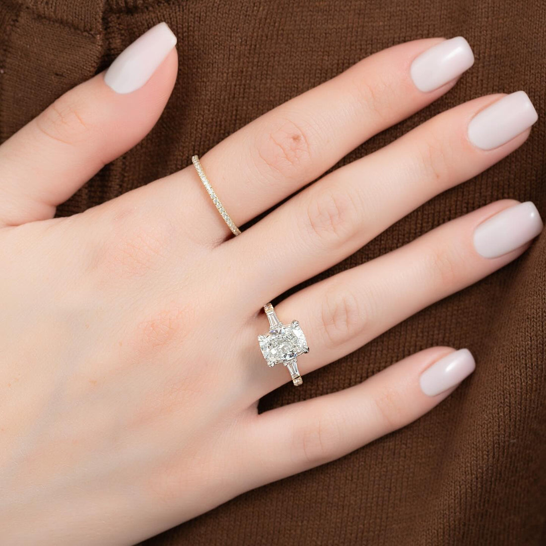 Elongated cushion lab grown diamond ring with tapered baguette sides worn on the hand