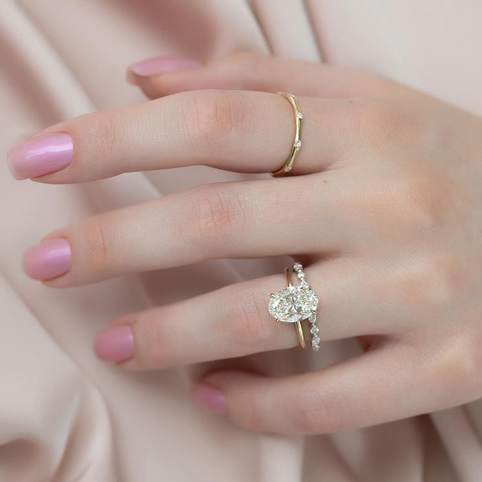 Oval lab grown diamond bridal ring set worn on the hand