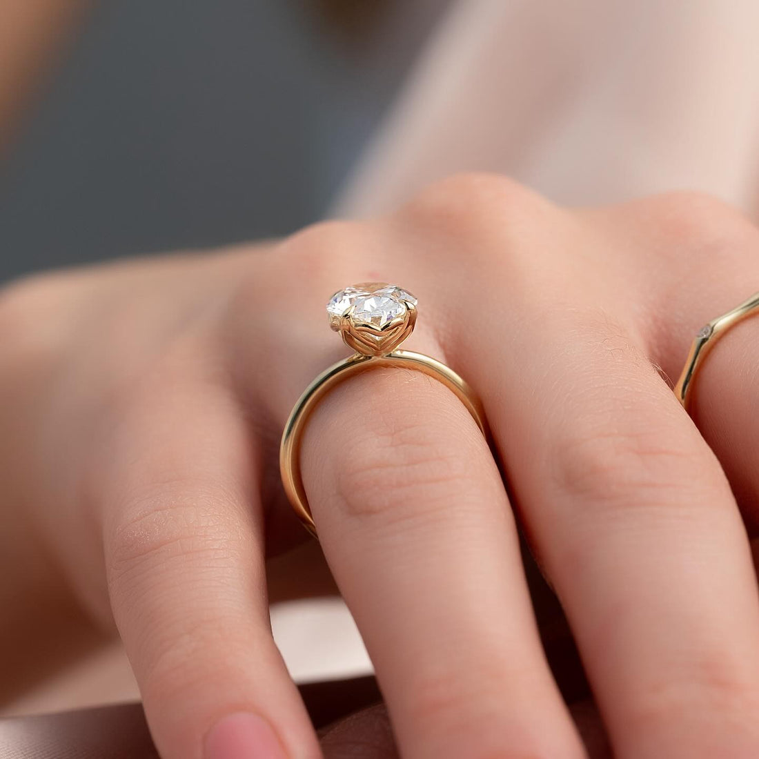 Oval cut lab grown diamond ring with a sculpted petal basket in yellow gold