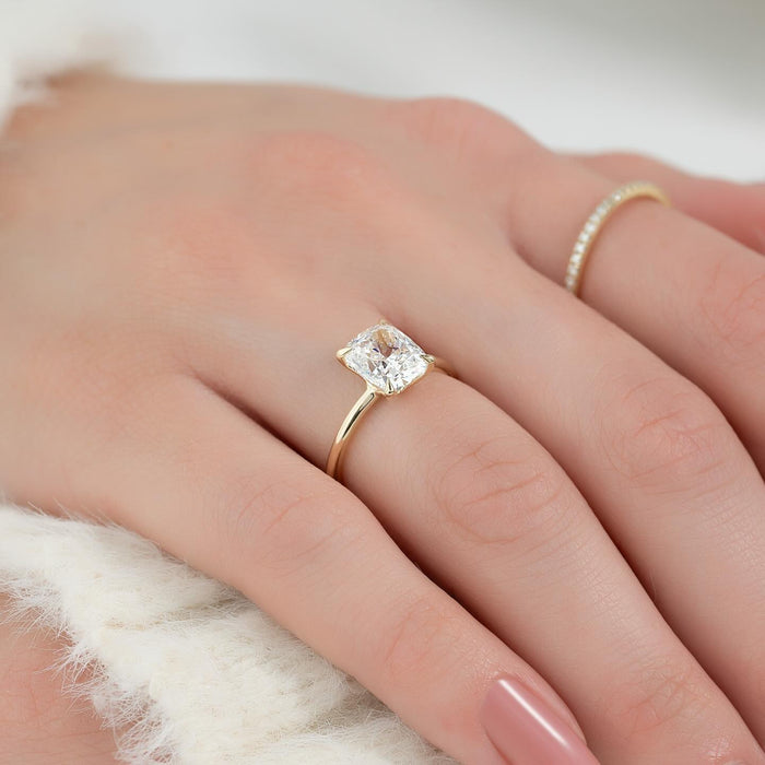 Cushion cut moissanite solitaire ring on a thin yellow gold band