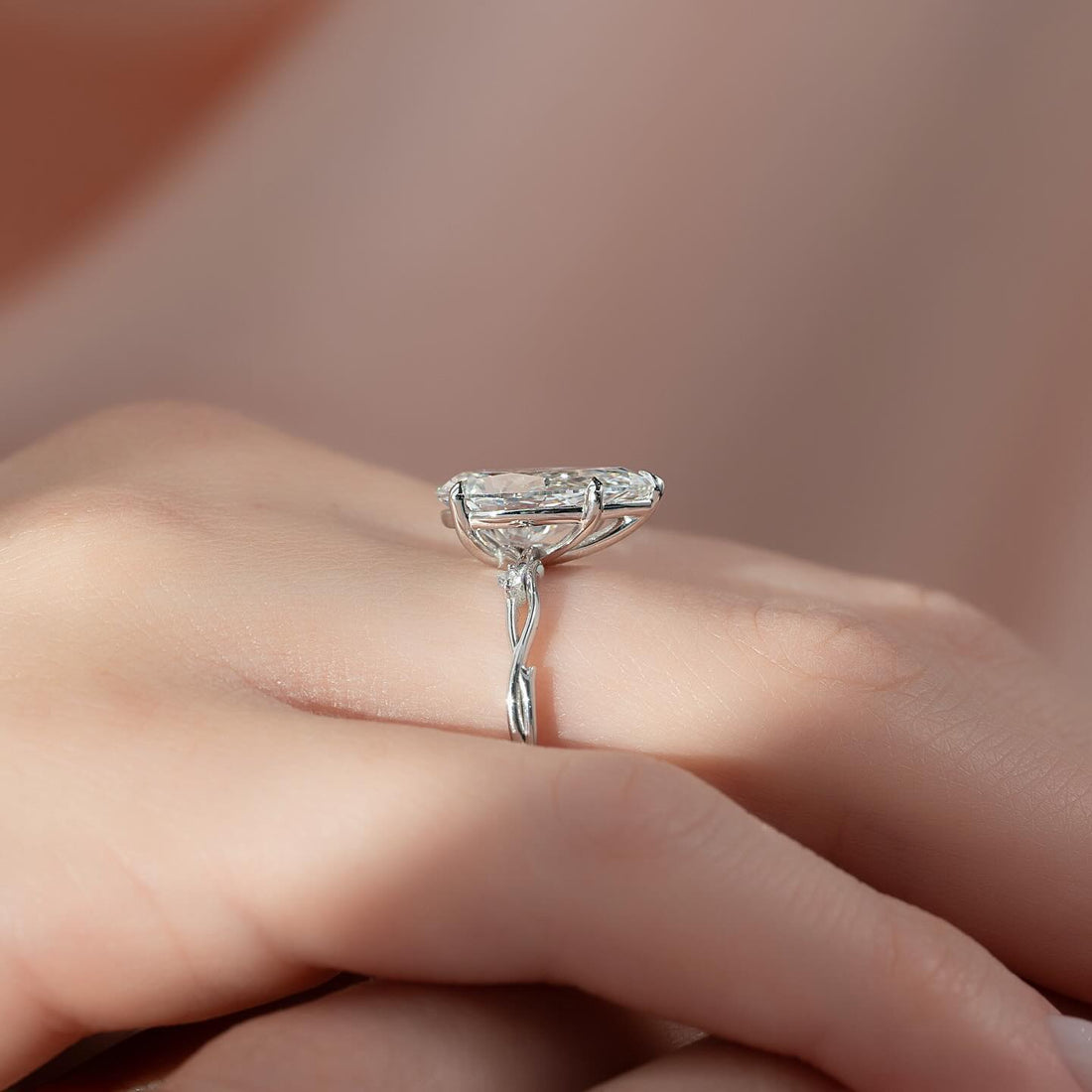 Pear moissanite solitaire ring on a vine band profile in white gold