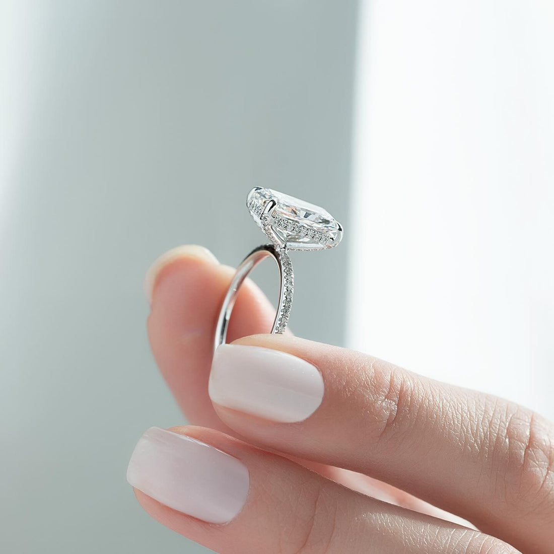 Profile of an elongated radiant cut lab grown diamond ring in white gold with a concealed halo