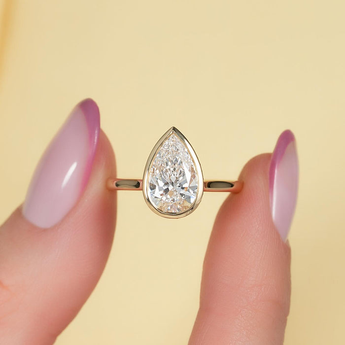 Pear cut lab grown diamond full bezel solitaire ring in yellow gold, front view