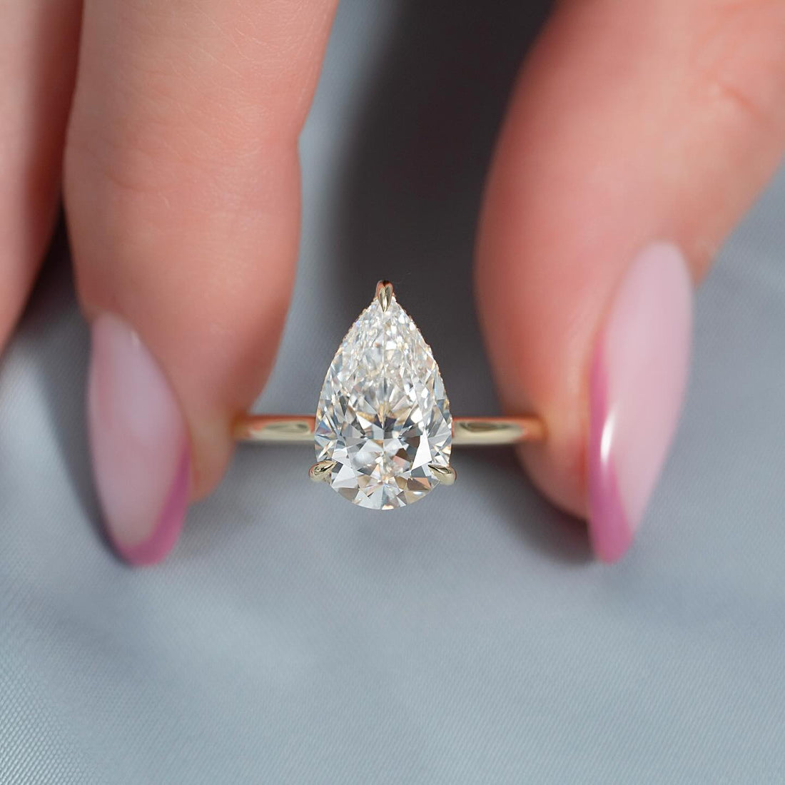 East west pear cut lab grown diamond engagement ring with hidden halo