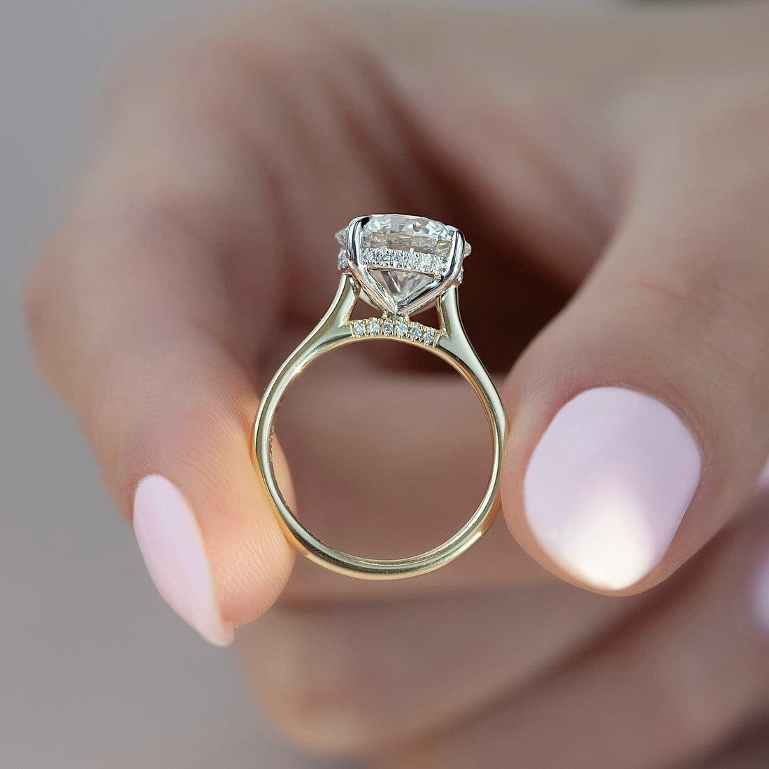 Round brilliant lab grown diamond ring with hidden halo and pave set bridge in yellow gold