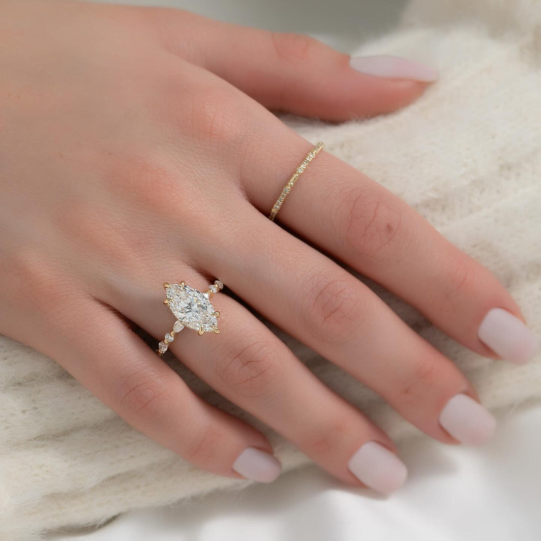 Marquise cut lab grown diamond ring with vintage station accent band in yellow gold worn on the hand