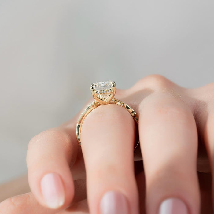 Emerald cut moissanite hidden halo twisted band ring profile in yellow gold