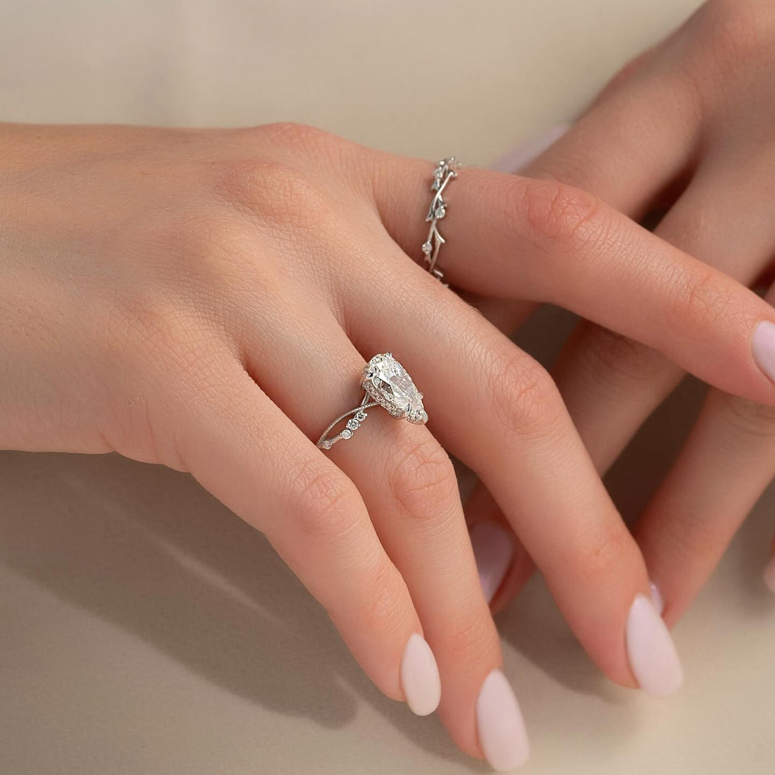 Pear cut lab grown diamond ring with leaf side accents and vine shank in white gold