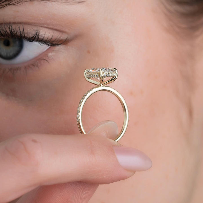Oval moissanite hidden halo ring side profile in yellow gold with pave band