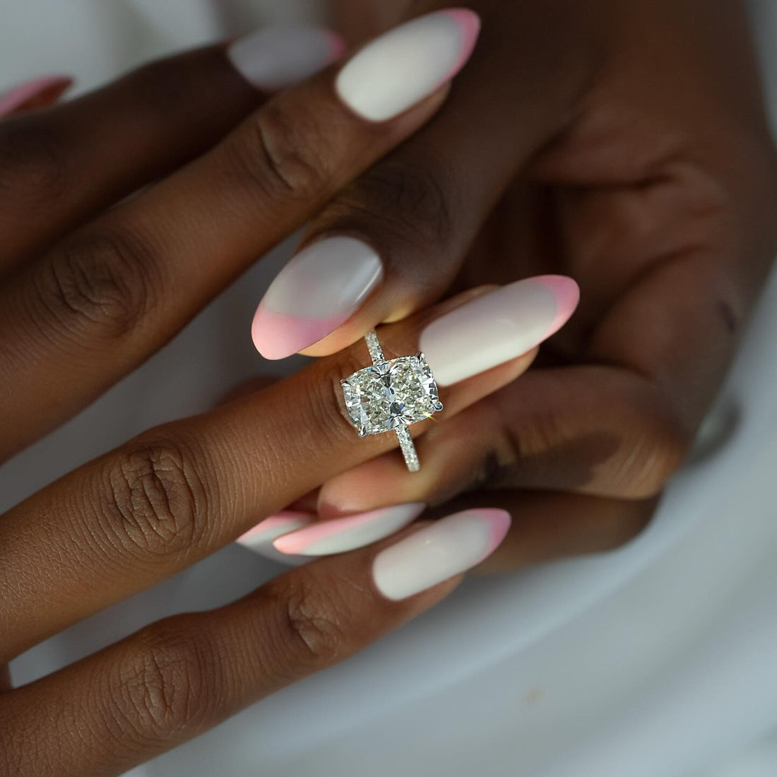 Elongated cushion lab grown diamond ring with pave basket and micro pave band in white gold worn on the hand