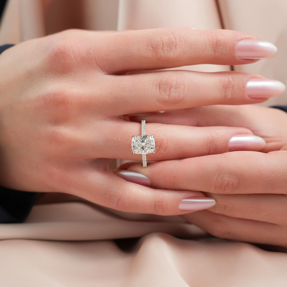 Elongated cushion lab grown diamond ring with fine pave shoulders in white gold worn on the hand