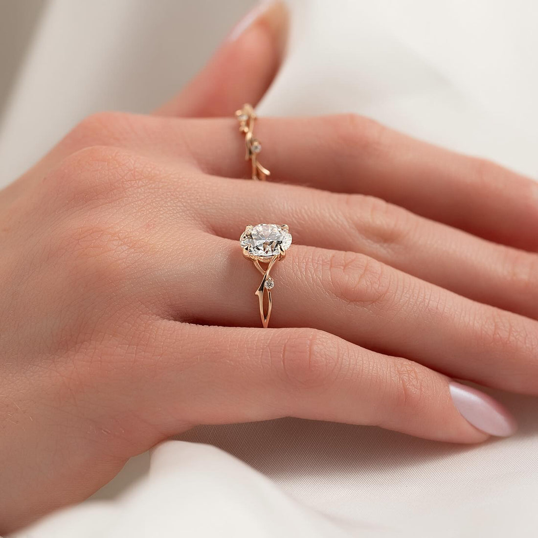 Round brilliant lab grown diamond ring with twisted vine band in rose gold worn on the hand
