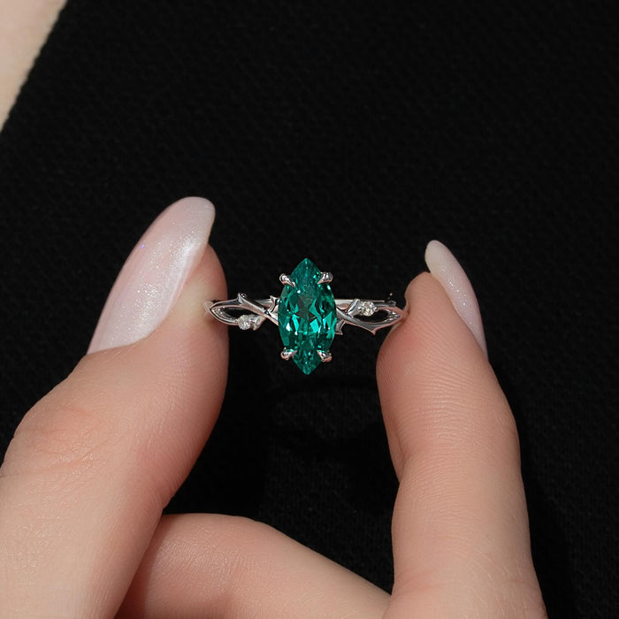 Vivid green marquise emerald set east west with round diamond accents