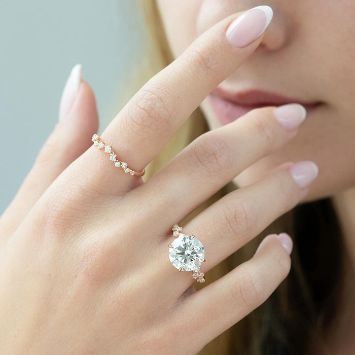Round brilliant lab grown diamond ring with clustered trio accents worn on the hand