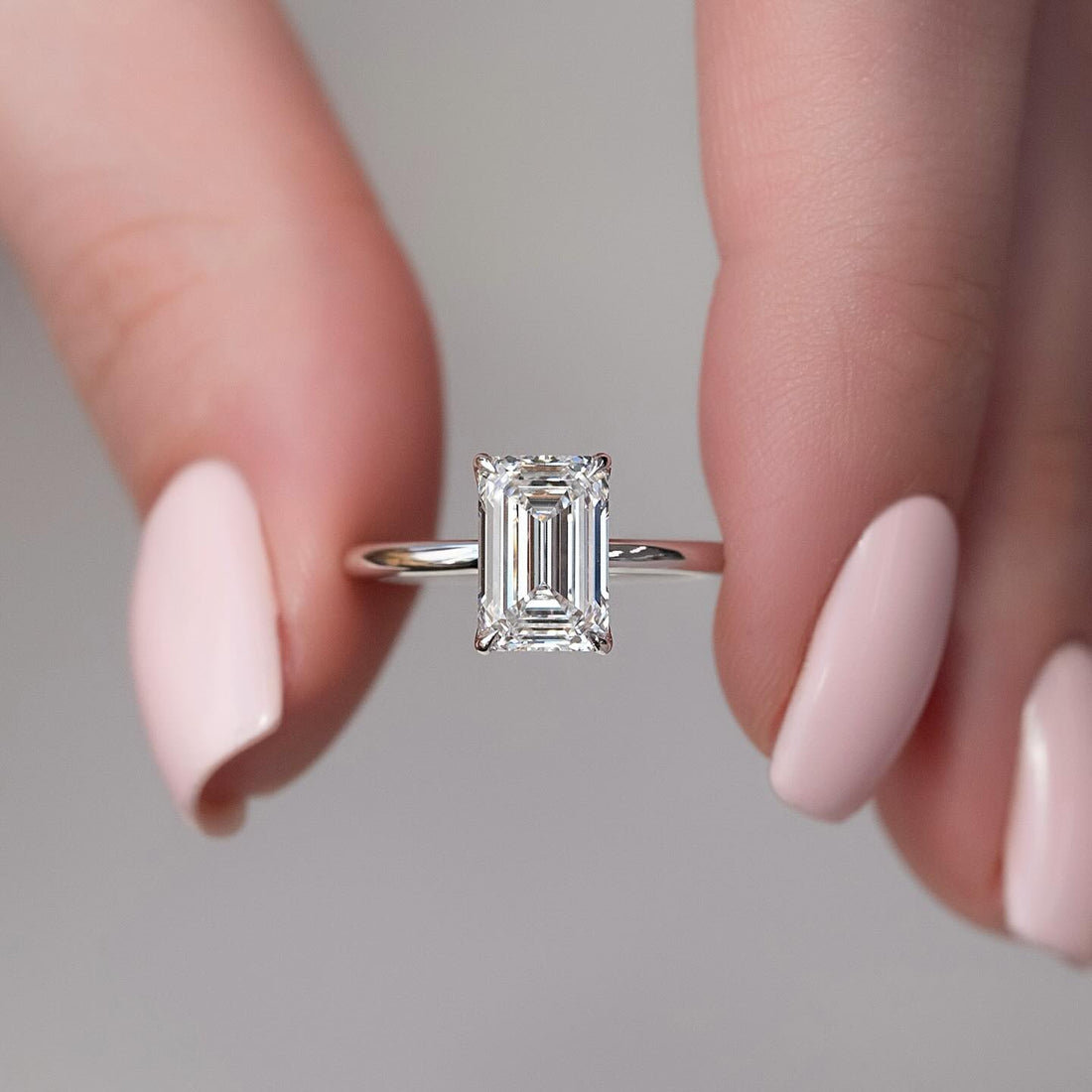 Emerald cut lab grown diamond solitaire ring in white gold with corner claws on a fine polished band