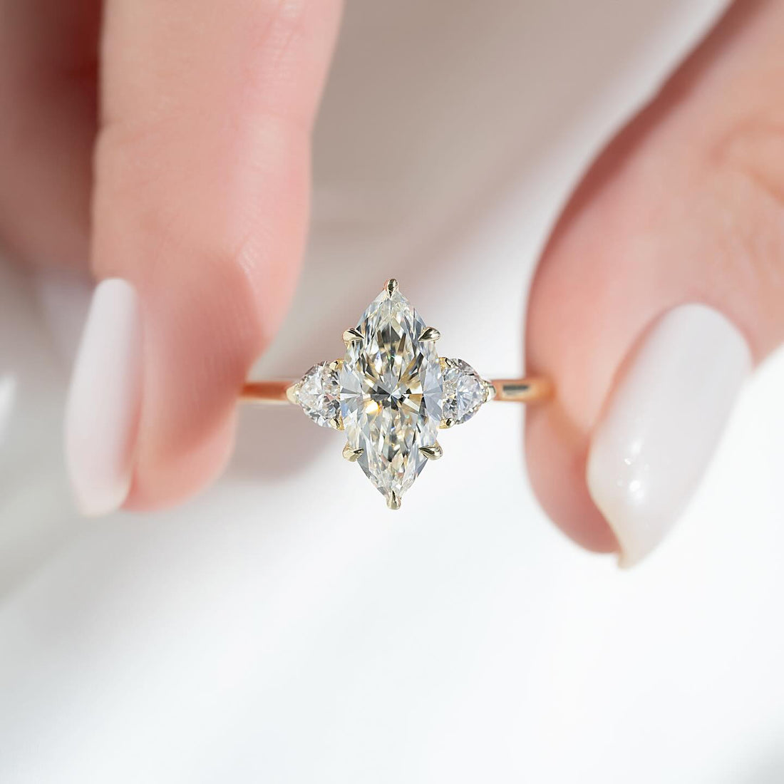 Marquise cut lab grown diamond ring with heart cut side stones in yellow gold