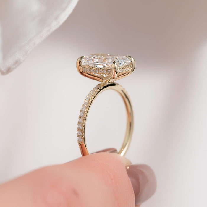 Elongated radiant cut lab grown diamond ring with hidden halo and pave band in yellow gold