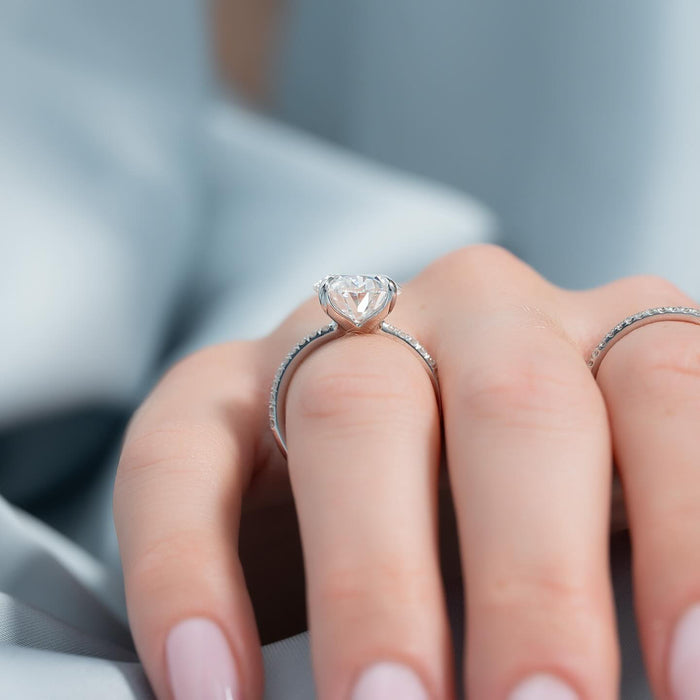 Oval cut lab grown diamond pave band engagement ring worn on the hand