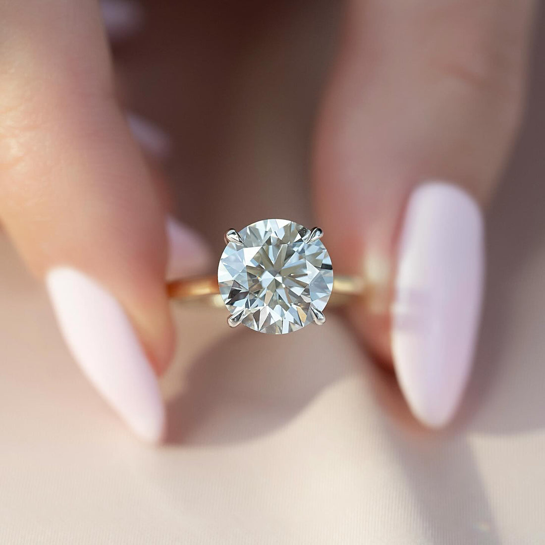 Round brilliant lab grown diamond solitaire ring with white gold claws on a yellow gold band