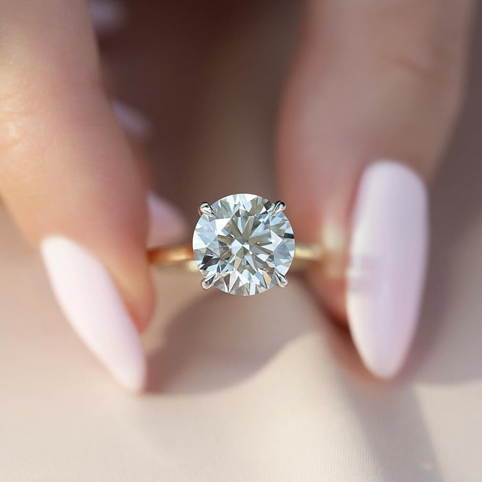Round brilliant lab grown diamond solitaire ring with white gold claws on a yellow gold band